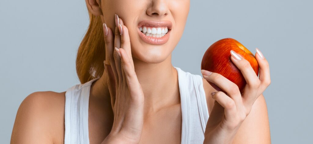 อาการฟันคุดเมื่อไหร่ควรพบแพทย์ Tooth problems. Young woman having toothache, biting apple